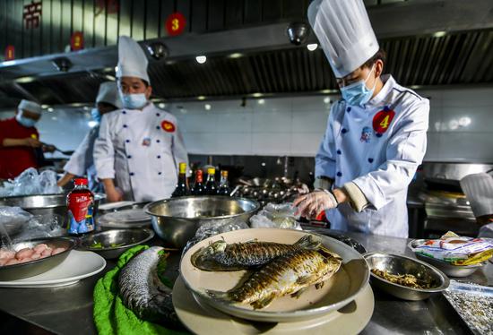 参赛选手用当地的野生鱼烹饪美食。中新社记者 刘新 摄