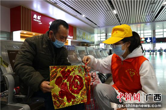 春运首日，桂林火车站青年志愿者向旅客赠送“福”字。郑长贤 摄