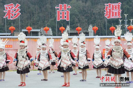 在“村晚”现场，苗族姑娘身着盛装踩鼓，共度佳节。邰春 摄