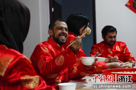 马万（左二）展示自己包好的饺子。董易鑫 摄