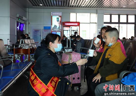 图为桂林火车站青年志愿者在候车室为旅客送姜糖水。郑长贤 摄