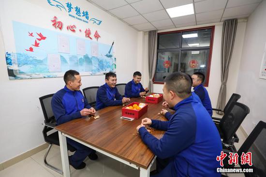 图为1月31日晚，邹曹（左二）在结束当天的执勤战备工作后和同队成员聊天。 瞿宏伦 摄