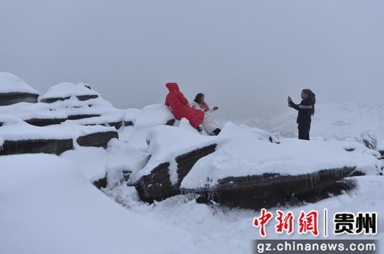 游客在贵州省铜仁市松桃苗族自治县盘石镇当造村红石林赏雪。