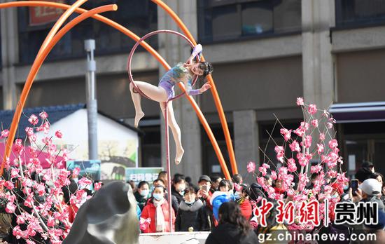 2月3日，人们在贵阳市南明区青云路步行街观看杂技表演。