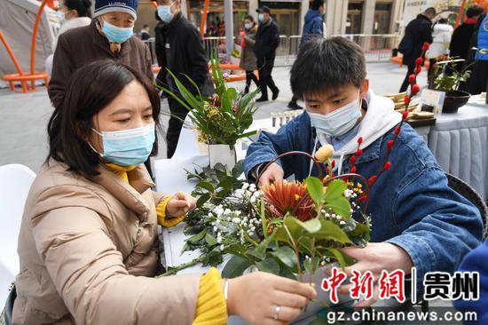 2月3日，人们在贵阳市南明区青云路步行街体验插花艺术。