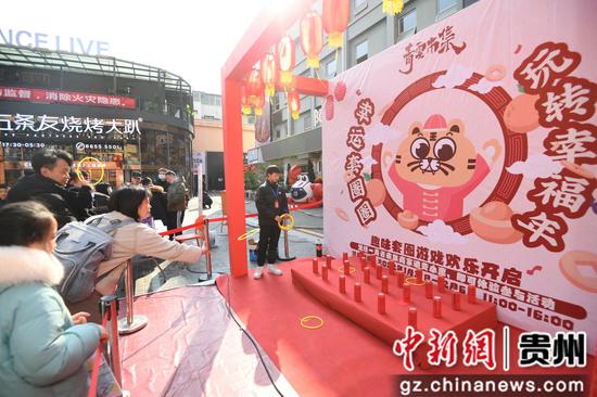 2月3日，在贵阳市南明区青云路步行街，人们正参与趣味套圈游戏。