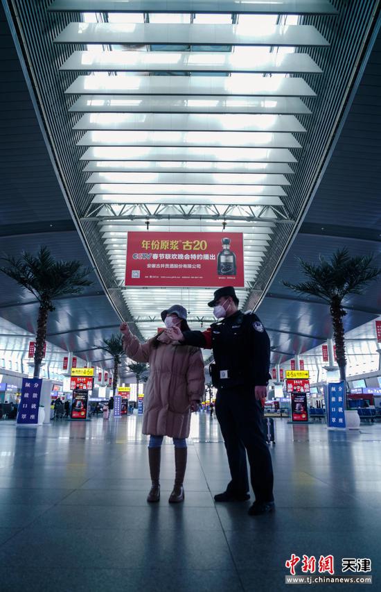 天津站派出所民警为车站旅客答疑解惑。