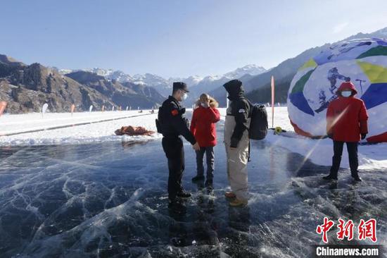 春节期间，民辅警在天山天池景区为游客叮嘱冰上安全常识。　陶拴科 摄