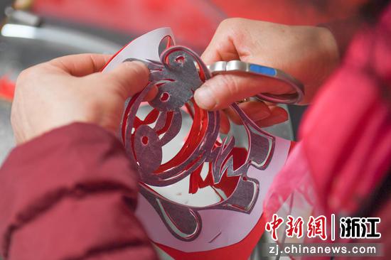 杨国花在创作北京冬奥会吉祥物冰墩墩剪纸作品。 王刚供图