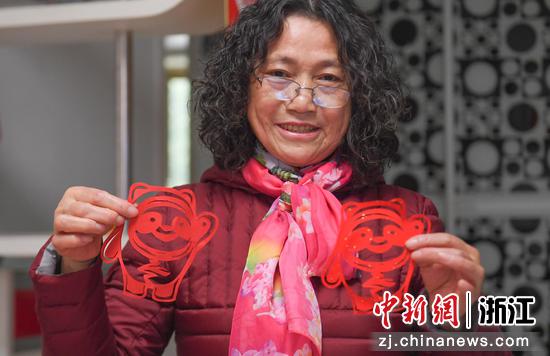 杨国花展示其创作的北京冬奥会吉祥物冰墩墩剪纸作品。 王刚供图