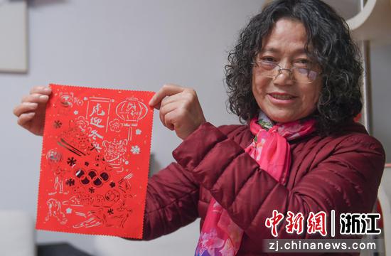 杨国花展示其创作的北京冬奥会主题剪纸作品。 王刚供图