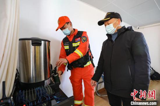 2月14日，一名消防救援人员在梵净山顶消防巡防执勤点给游客倒水。　瞿宏伦 摄