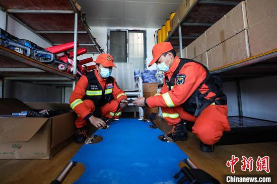 2月14日，两名消防救援人员在梵净山顶消防巡防执勤点检查担架。　瞿宏伦 摄