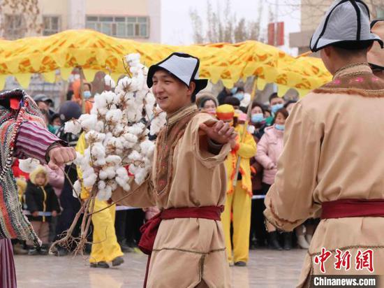 新疆尉犁县元宵节文化活动中，表演者手持棉花，笑容满面。　胡嘉琛　摄