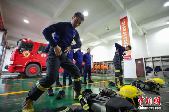 2月17日，因大雾弥漫，消防救援人员只能在车库进行原地着装训练。 瞿宏伦 摄