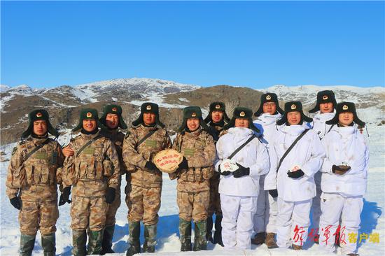 新疆阿勒泰军分区阿黑吐拜克边防连巡逻官兵与玉峡峡执勤点官兵互送礼物，合影留念。 段伟 摄