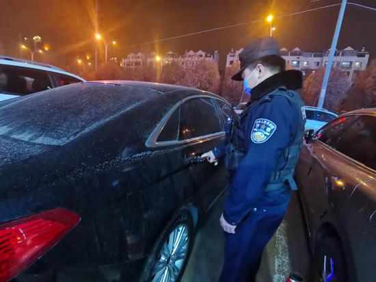 警务人员正在检查车辆落锁情况。昌吉市公安局建国路派出所供图