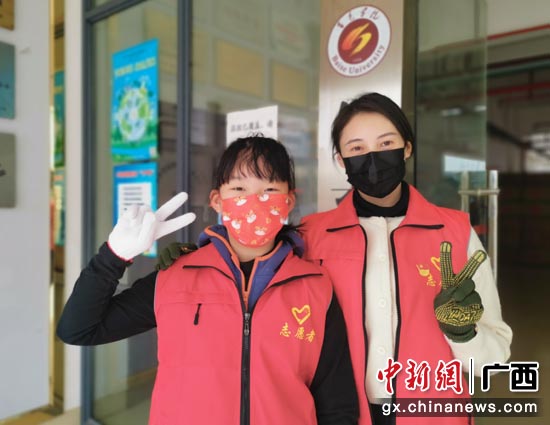 人民银行百色市中心支行赵华斯母女齐上阵协助物资搬运。刘桂武 摄