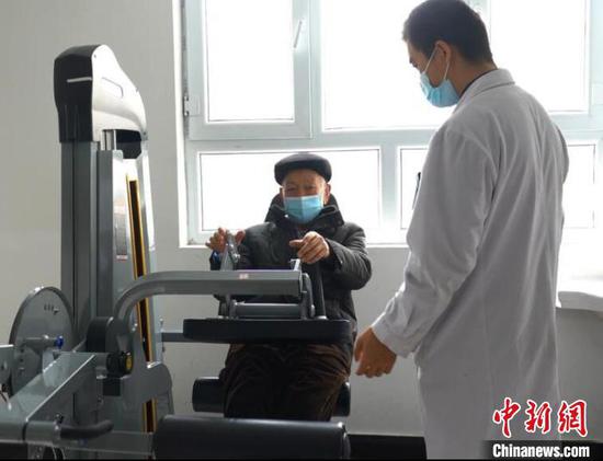 图为新疆阿克苏地区康养中心内，医护人员帮助老人做康复治疗。　左丹丹　摄