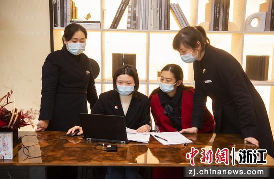 浙江金华一银行工作人员（左二）演示购房网签和贷款“一次办”流程。  时宽兵 摄