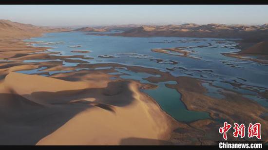 位于库木库里沙漠腹地的沙子湖薄冰化尽，蔚蓝的湖水与金黄的沙山、辽阔的碧空交相辉映。　尚鹏 摄