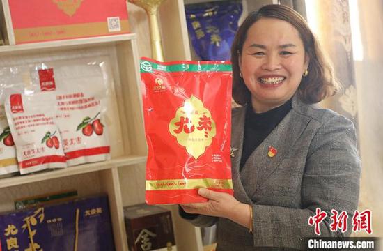 图为尤良英展示以自己名字命名的红枣品牌及包装。(张涛 摄)