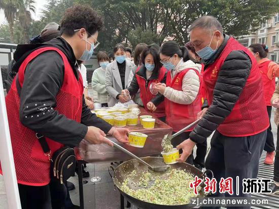 志愿者热心地为居民们分发着芥菜饭。  叶青青 摄