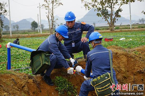 崇左供电公司党员服务队帮助农户调试灌溉管道。卢卓景 摄