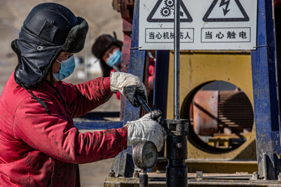 新疆油田員工正在對抽油機進行提光桿操作。
