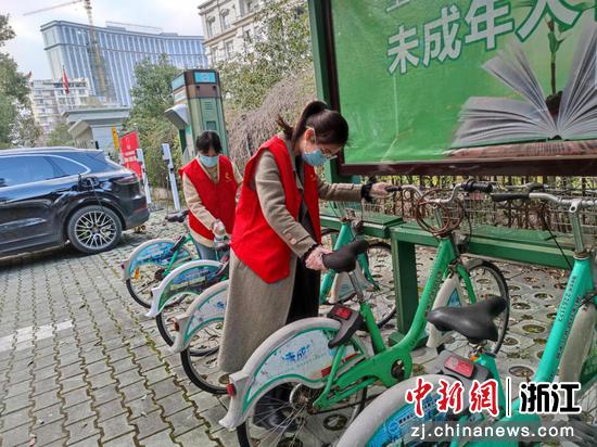 丽水市烟草专卖局“香溢”志愿者唐丽、刘婷婷对公用自行车进行整理并消毒。雷萌 摄