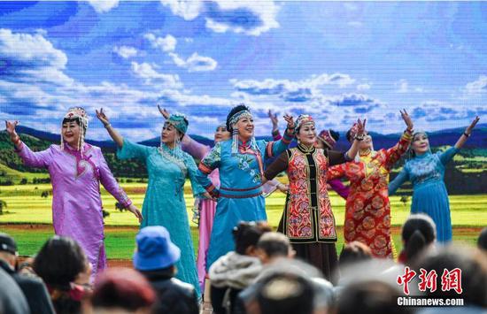 3月8日，新疆乌鲁木齐市大巴扎景区，“最美妈妈”们身着华丽的民族服饰，在舞台上进行展示。当天，“展风华 秀风采”庆祝“三八”国际妇女节活动在该景区举办，百余名女性同胞欢聚一堂，唯美的民族服饰秀，曼妙的旗袍走秀吸引众多过往市民及游客驻足观看。 中新社记者 刘新 摄