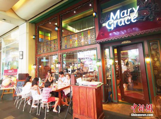 3月13日，菲律宾首都马尼拉CBD马卡蒂商圈GREENBELT商城，著名本土连锁餐厅Mary Grace，内外场都坐满了食客。目前，马尼拉疫情处于低风险状态，市民进出餐厅已不需要出示疫苗接种证明，餐饮业可全场接待，生意兴隆。 中新社记者 关向东 摄