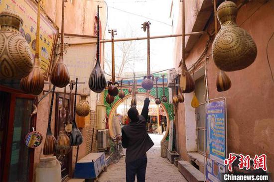 新疆喀什古城吾斯塘博街，小巷中挂着各类民族乐器成为别致一景。　李彩琴　摄