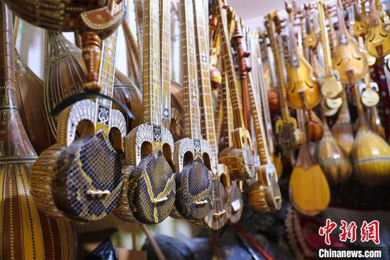 马木提江·亚森10余平方米的小店中摆满自制的乐器。　李彩琴 摄