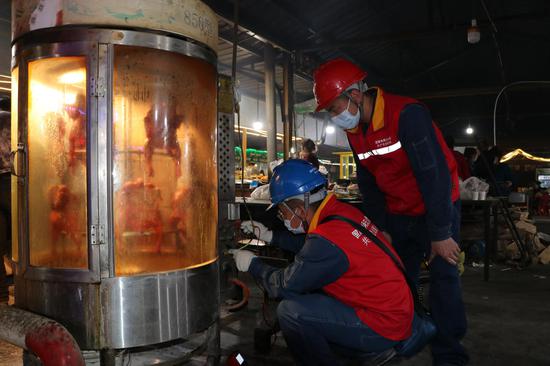 3月17日，国网喀什供电公司员工走进夜市检查用电设备。杨文凯 摄