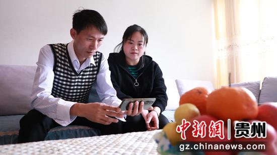 新兵韦玉的父母亲韦健平、绍国芳在家观看仪式。