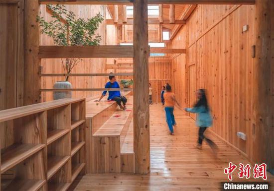 陈国栋为榕江归柳村一位教师免费设计的房屋，村里小孩在屋内玩耍。　受访者供图