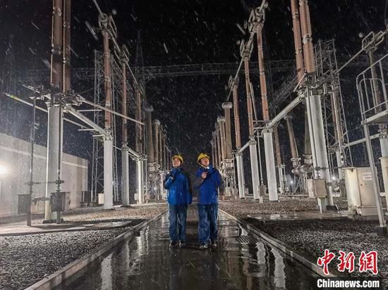 23日，国网新疆电力超高压分公司员工在750千伏凤凰变电站进行夜间大雪特巡工作。　吴珂 摄