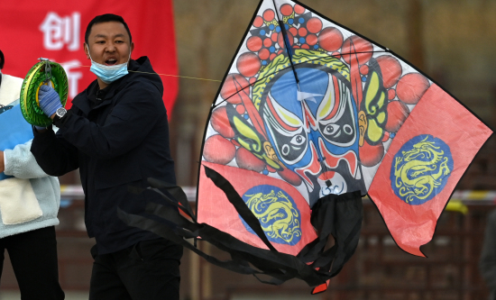 选手在新疆库尔勒市鸿雁河广场准备放风筝。
