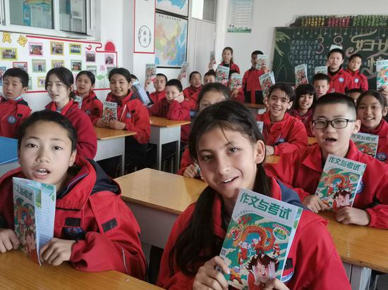 新疆阿克苏地区温宿县第六中学六（2）班的学生们一起阅读《作文与考试》