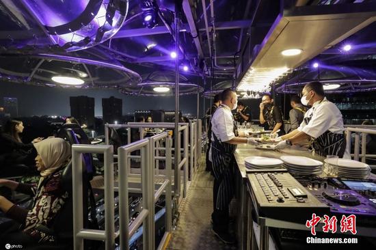 当地时间2022年3月30日，印尼雅加达，当地推出的“空中餐厅”成为新旅游景点，顾客在高空享用美食，该餐厅由起重机吊起。图片来源：ICphoto