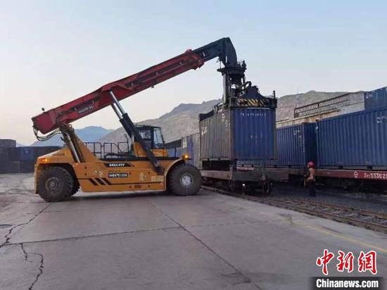 新疆库尔勒货运中心鱼儿沟营业部正在装运集装箱。　袁文浩 摄