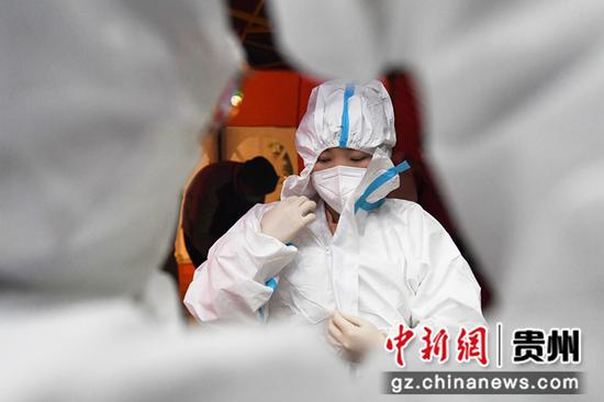 4月6日，在贵阳市南明区亨特片区、官井片区第2次区域核酸检测点，医护人员正在穿防护服。