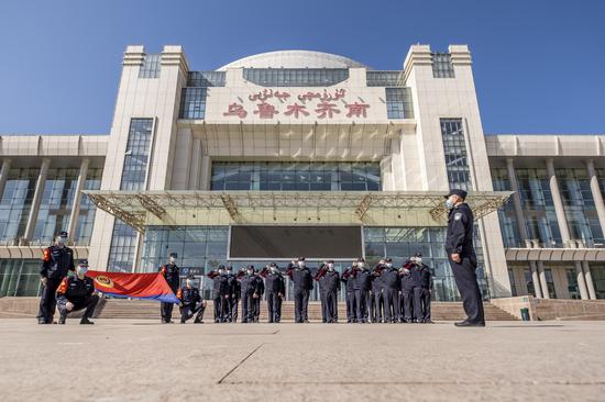 乌鲁木齐南站派出所民警面向警旗宣誓。