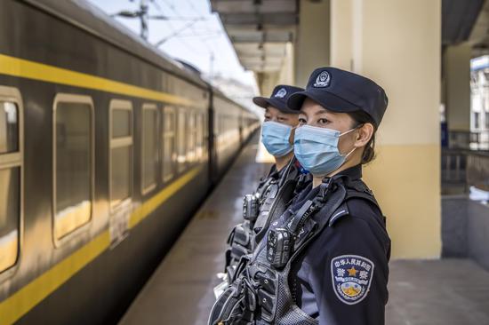 民警对站内停留旅客列车进行安全检查。