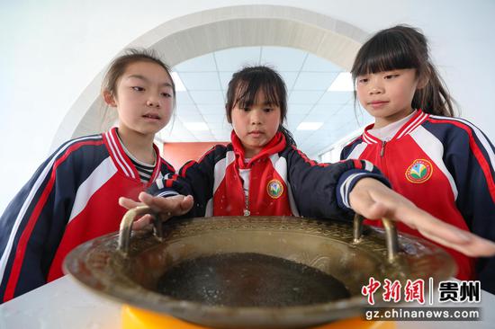 4月8日，骊龙小学学生在体验“鱼洗”仪器。 瞿宏伦 摄