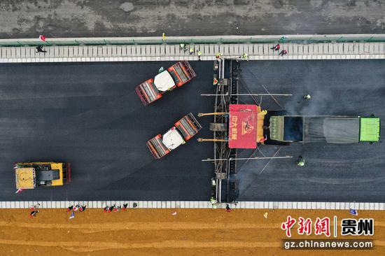 贵州公路集团工人在进行沥青铺筑作业。 瞿宏伦 摄