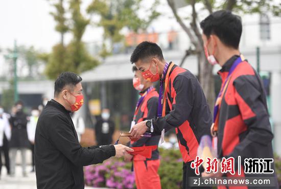 男子马拉松冠军杨绍辉在颁奖仪式上自己拿起纪念品。 王刚 摄