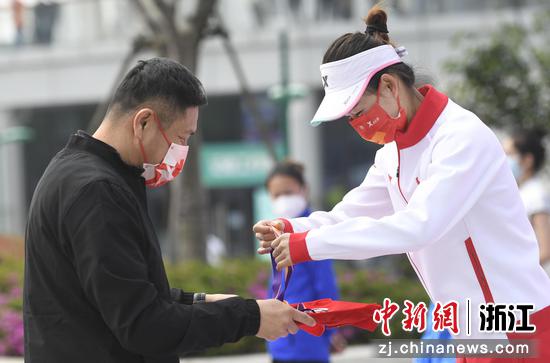 女子10公里竞走获奖选手在颁奖仪式上自己拿起奖牌。 王刚 摄