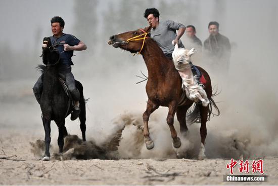 4月16日，新疆库尔勒市阿瓦提乡喀拉亚尕奇村四组，群众在进行刁羊比赛。当日，新疆库尔勒市阿瓦提乡举办春季旅游活动，当地群众参加刁羊比赛，吸引众多游客观看。 中新社发 确·胡热 摄 图片来源：CNSphoto